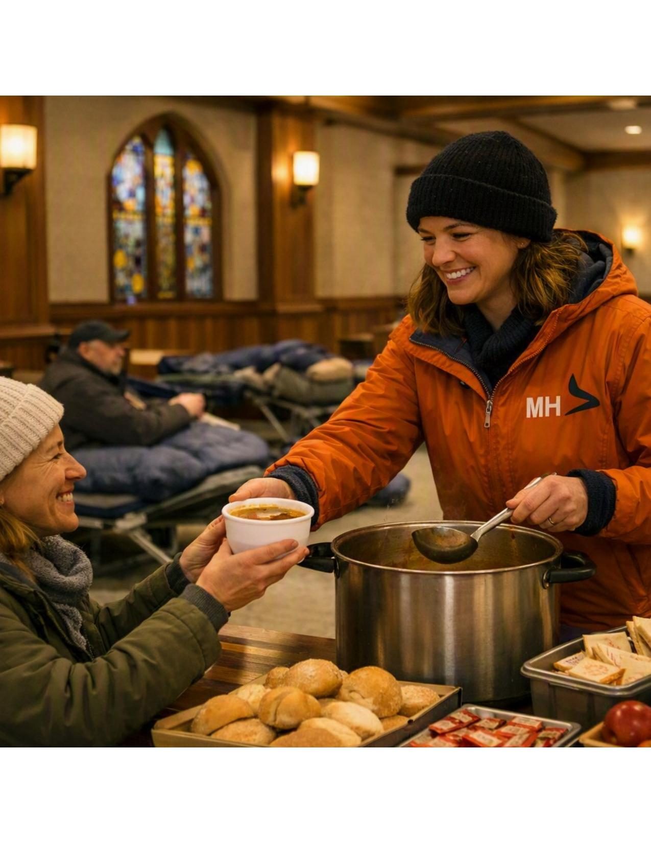 A Mobile Hearth volunteer serving hot soup to a guest inside a partner church